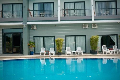 a hotel with a swimming pool in front of a building at KEP BAY HOTEL & RESORT in Kep