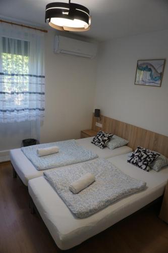 two twin beds in a room with a window at Május 1 Vendégház - Torony in Torony