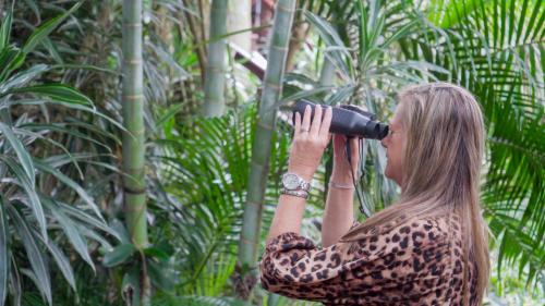 a woman taking a picture of some plants with a camera at Luxury Tented Village @ Urban Glamping in St Lucia