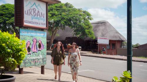 two women walking down a sidewalk in front of a sign at Luxury Tented Village @ Urban Glamping in St Lucia