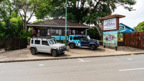 two jeepneys parked in front of a building at Luxury Tented Village @ Urban Glamping in St Lucia