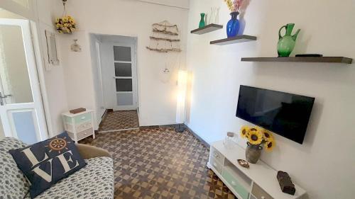 a living room with a couch and a flat screen tv at Casa Marina 50 mt dal mare in Imperia