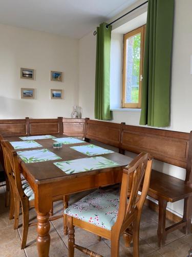 a dining room with a wooden table and chairs at Gîte des Pommiers avec terrain de pétanque in Le Fresne-Poret