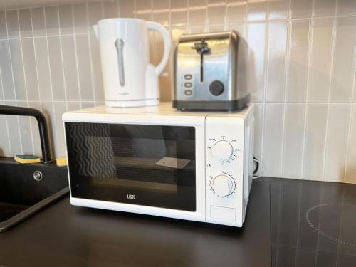 - un four micro-ondes sur un comptoir de cuisine avec une cafetière dans l'établissement Magnifique T2 proche Orly et RER C, à Choisy-le-Roi