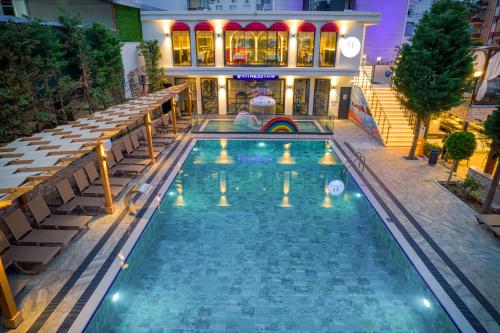 a swimming pool in front of a building at night at Club Big Blue Suit Hotel - All Inclusive Plus in Alanya