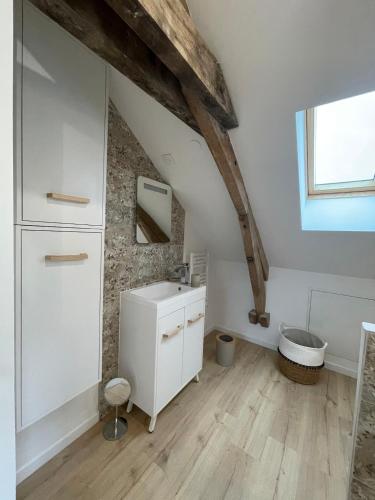 La salle de bains mansardée est pourvue d'un lavabo et de toilettes. dans l'établissement La Ferme Authentique Gîte familiale, à Saint-Sulpice-dʼExcideuil