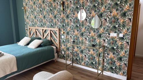 a bedroom with a wall with a tropical wallpaper at Casa da alegria in Vau