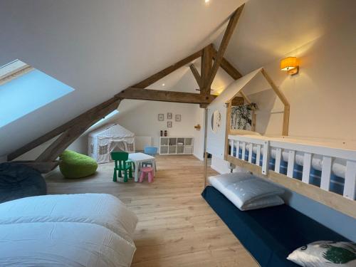 - une chambre mansardée avec un lit et une table dans l'établissement La Ferme Authentique Gîte familiale, à Saint-Sulpice-dʼExcideuil