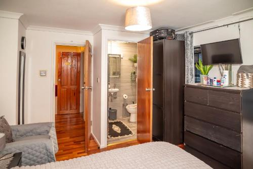 a living room with a bed and a bathroom at King Size - Ensuite Room in London