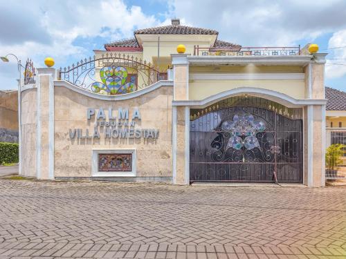 a building with a gate with a sign on it at Palma Villa Homestay Klaten in Kuwoso