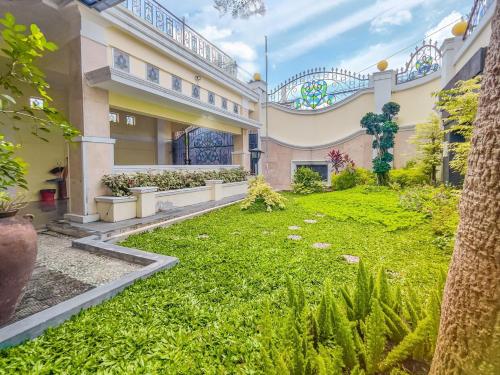 a courtyard of a building with a yard of grass at Palma Villa Homestay Klaten in Kuwoso