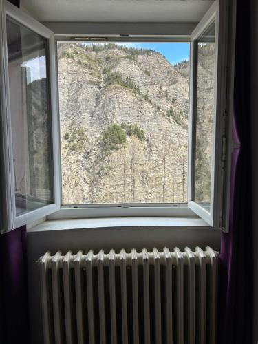 a window with a radiator in front of a mountain at le Belvédère Maison d hotes in Sainte-Anne