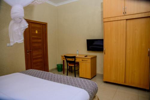 a bedroom with a bed and a desk with a television at Quality Inn Hotel Kigali in Kigali