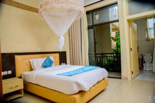 a bedroom with a bed with a chandelier above it at Quality Inn Hotel Kigali in Kigali