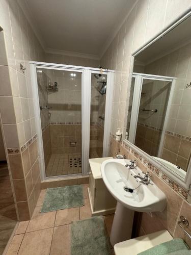 a bathroom with a sink and a shower at Peony Place in Cape Town