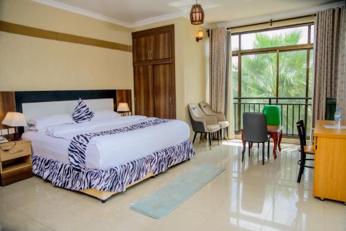 a bedroom with a bed and a desk and chairs at Quality Inn Hotel Kigali in Kigali