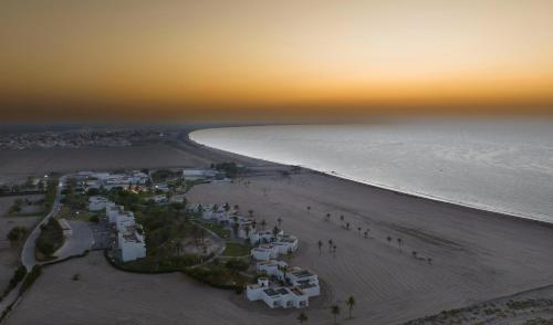 an aerial view of a beach at sunset at Al Sawadi Beach Resort & Spa in Barka