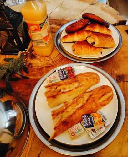 two plates of food on a wooden table with food at Duplex Safari jusqu'à 4 personnes, Spa, cinéma et lit sous les arbres, day use, 10 min centre in Amiens