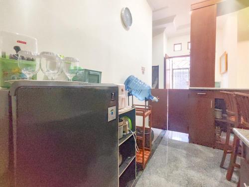 a kitchen with a refridgerator with wine glasses on it at Palma Villa Homestay Klaten in Kuwoso