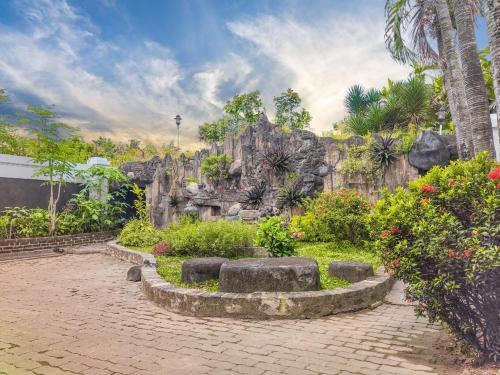 a garden in front of a rock wall at Palma Villa Homestay Klaten in Kuwoso