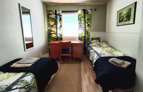 NakkilaにあるApartment Garage, Tallitaloのベッドが2つと机とテーブルがある部屋