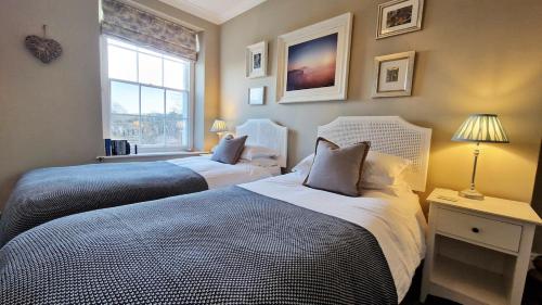 two beds in a room with a window at Belvedere Lodge Swanage Dorset Sea View Luxury in Swanage