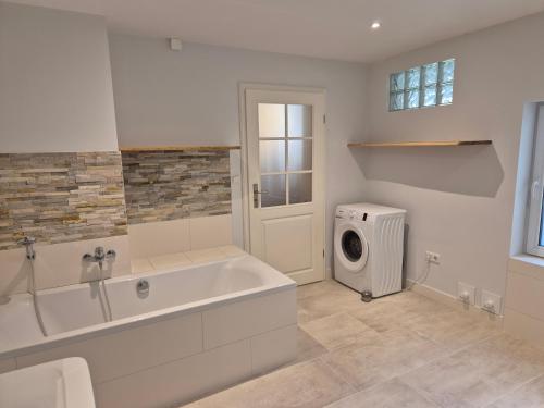 a bathroom with a tub and a washing machine at Windstiller Hafen in Flensburg