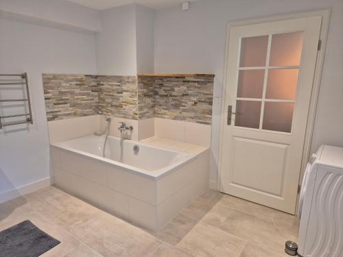 a white tub in a bathroom with a window at Windstiller Hafen in Flensburg