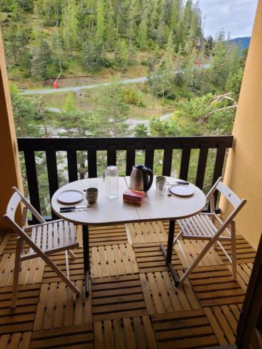 une table et des chaises sur un balcon avec vue dans l'établissement Studio face aux pistes de La Colmiane, à La Colmiane