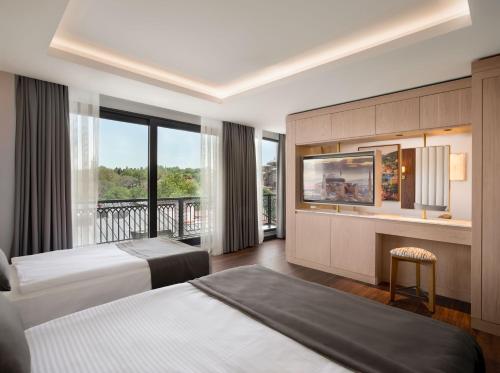 a hotel room with two beds and a balcony at Shining Star Hotel in Istanbul