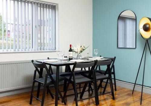 a dining room with a table with chairs and a mirror at Comfortable 3 Bedrooms Leeds Beach House - Ideal for Family and Contractors - Free WIFI, Projector in bedroom and Free Parking for 2 cars in Killingbeck