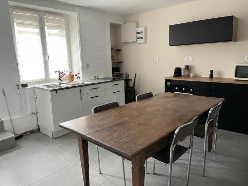 une cuisine avec une table et des chaises en bois dans l'établissement Le cocon de la vallée, à Fumay