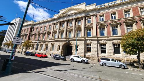 a large brick building with cars parked in front of it at Norton Suite - Christchurch Central in Christchurch