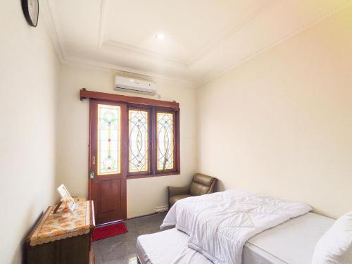 a bedroom with two beds and a window at Palma Villa Homestay Klaten in Kuwoso