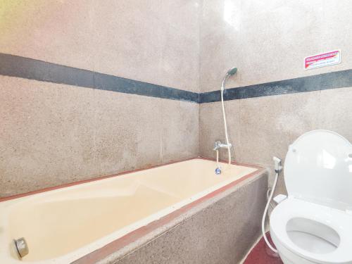 a bathroom with a bath tub and a toilet at Palma Villa Homestay Klaten in Kuwoso