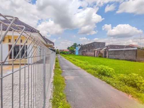 a fence on the side of a road next to a field at Palma Villa Homestay Klaten in Kuwoso