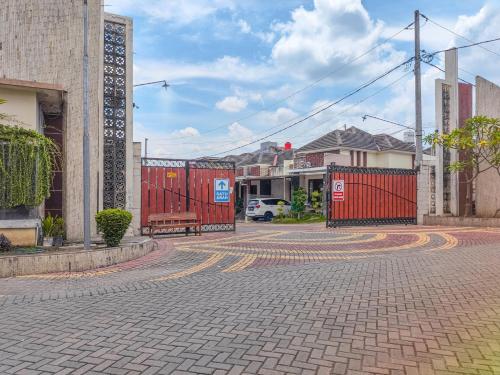 an empty street with a red fence and a bench at Palma Villa Homestay Klaten in Kuwoso