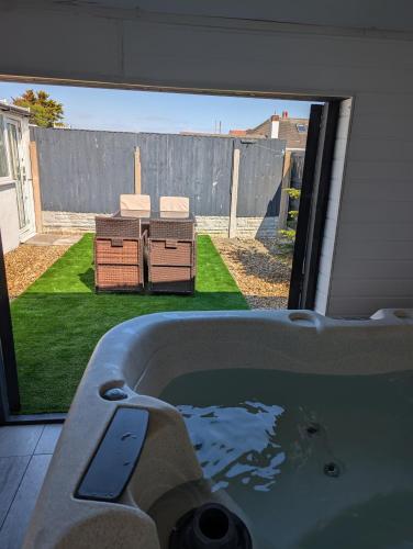 a bath tub with a view of a yard at Beach Links in Prestatyn