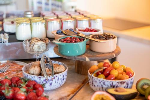 a buffet of food with bowls of fruits and vegetables at Tinah Saint-Tropez in Saint-Tropez