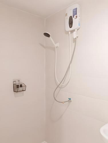 a shower in a bathroom with a white wall at Rest Inn China Town - Yaowarat BKK in Samphanthawong