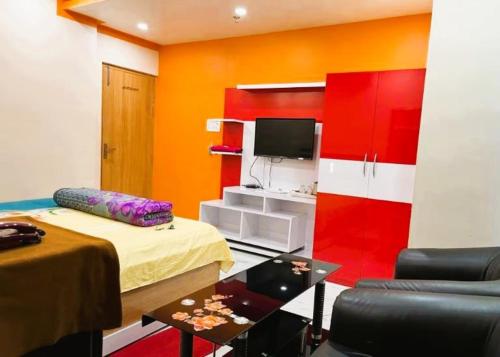 a room with a bed and a tv and a couch at Hotel Anurag Palace In Agartala in Agartala
