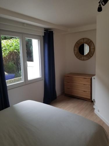 a bedroom with a bed and a window and a dresser at appartement cosy avec jardin Amboise in Amboise