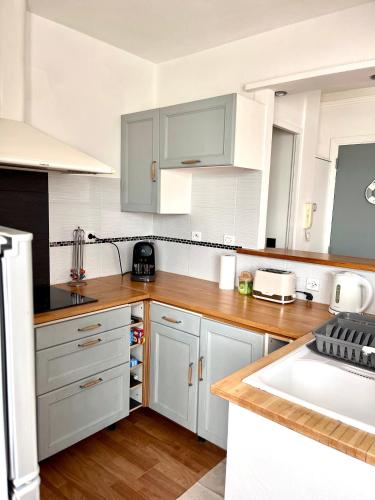 une cuisine blanche avec des armoires blanches et un évier dans l'établissement PORT DE HYERES - Appartement 40m2 - 4 personnes - place de PARKING, à Hyères