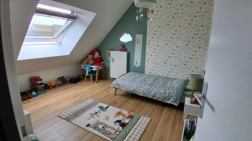 Dormitorio infantil con cama y ventana en Maison 170m2 entre ville et campagne, en Changé