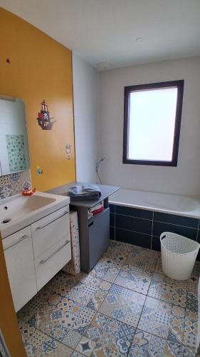 Un baño con bañera, lavabo y bañera. en Maison 170m2 entre ville et campagne, en Changé
