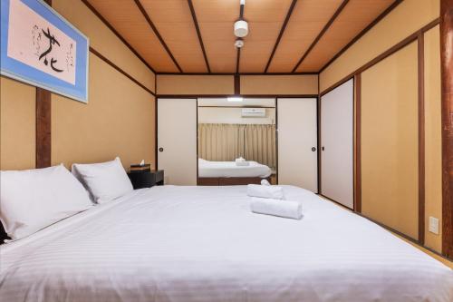 a bedroom with a large bed with white pillows at Shiki Homes HARU in Kyoto
