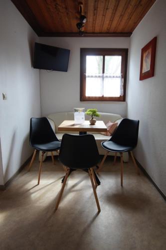 a room with a table and chairs and a window at Bungalowdorf Lübben in Lübben