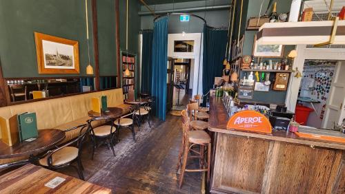 a bar with wooden tables and chairs in a restaurant at Norton Suite - Christchurch Central in Christchurch