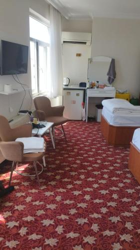 a room with two beds and a red carpet at Hotel Birkent in Diyarbakır