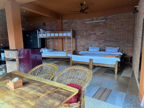 pokój z dwoma łóżkami, stołem i krzesłami w obiekcie Nar-Bis Hotel w mieście Pokhara
